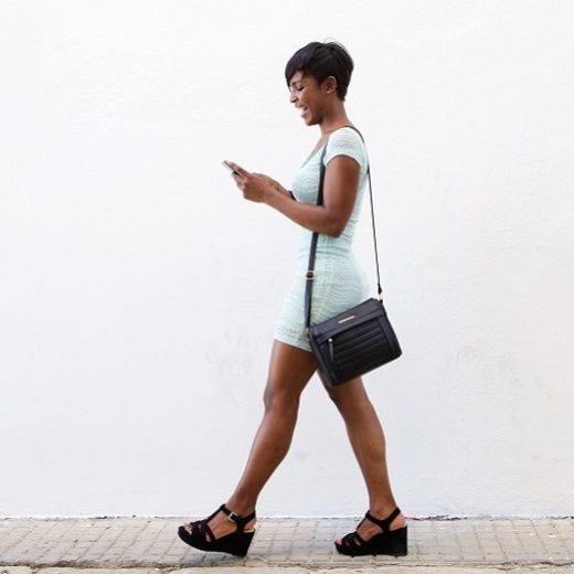 A smiling 30-something black man in a wheelchair wearing casual sports clothing.